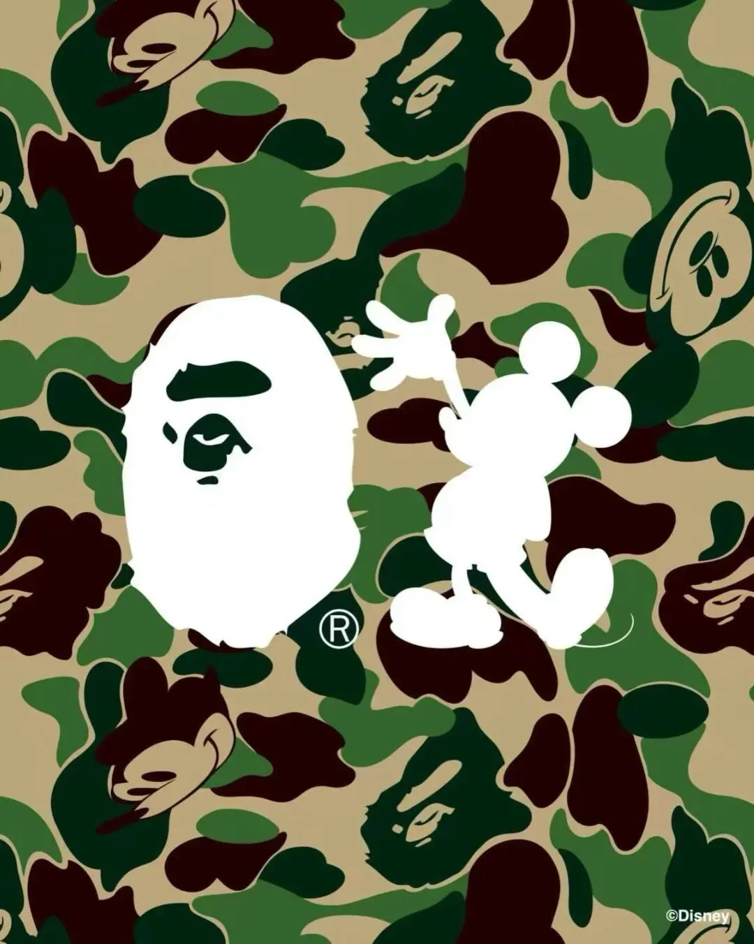 The Disney x A BATHING APE collaboration graphic features BAPE's signature green camouflage pattern as the background, overlaid with the iconic white Ape Head logo alongside a white silhouette of Mickey Mouse in his classic walking pose. Hidden Ape Head motifs are woven throughout the camouflage, blending Disney's most recognizable character with BAPE's unmistakable streetwear identity.