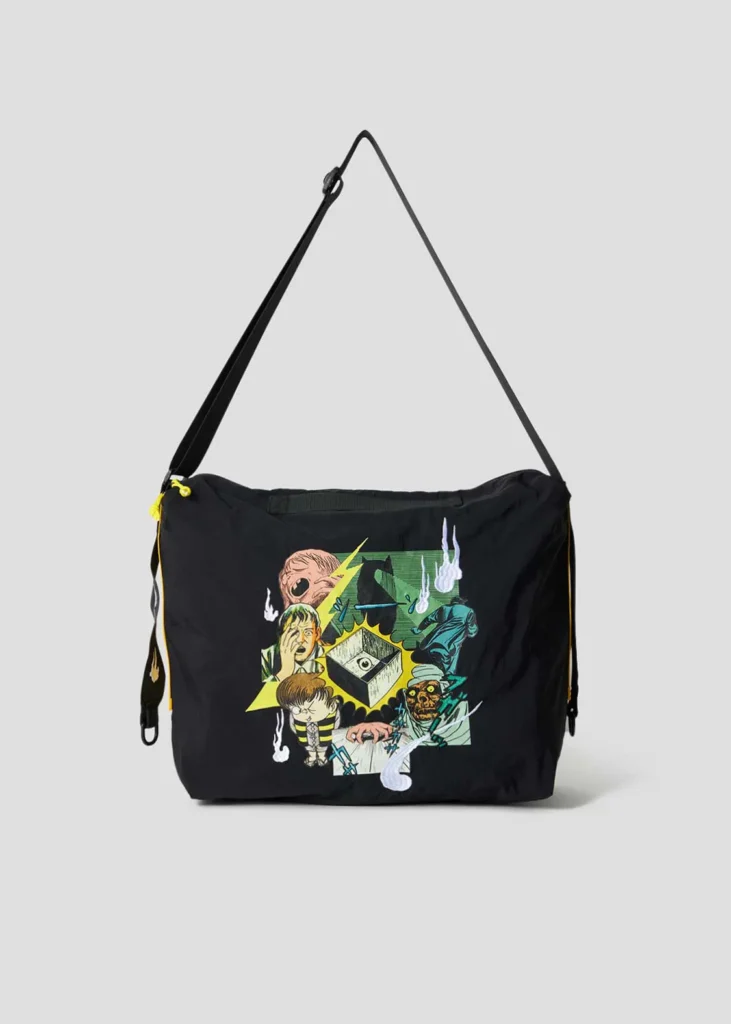 Black shoulder bag with an oversized front graphic featuring colorful GeGeGe no Kitarō artwork, adjustable strap, and yellow zipper accent