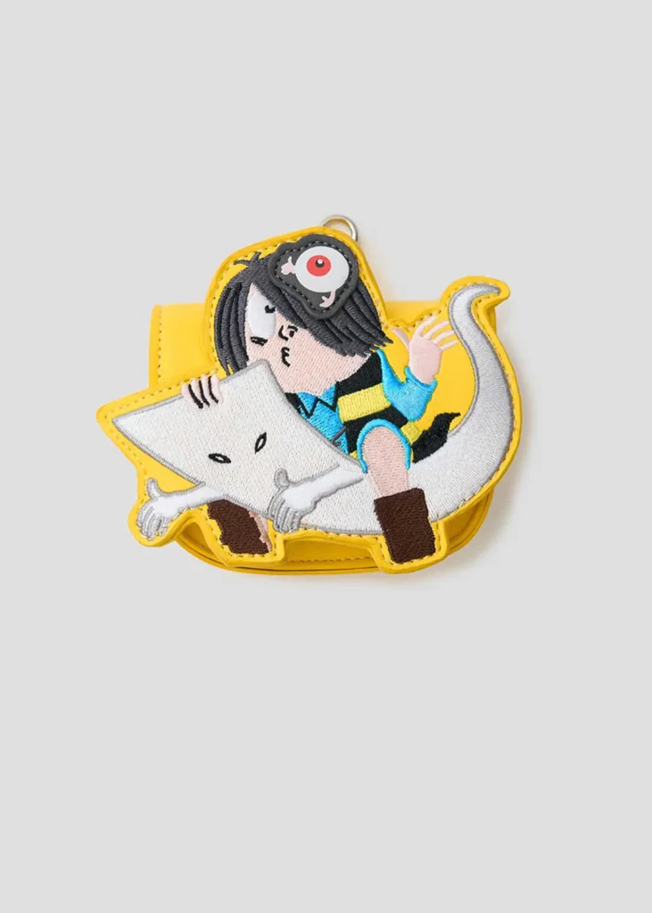 Bright yellow coin pouch shaped like Kitarō riding Ittan Momen with embroidered details, Eyeball Father accent, and zipper closure