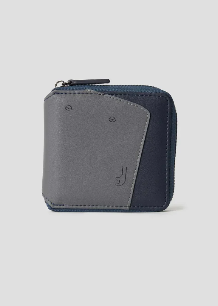 Gray and navy zip-around wallet featuring a simple embossed character face created from minimal line details on the front