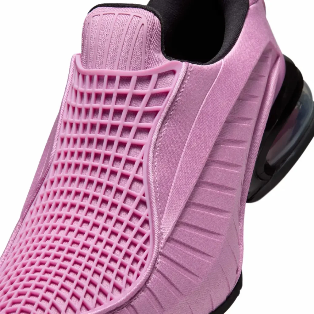 Close-up of the pink slip-on upper showcasing the flexible lattice cage, ribbed tongue panel, satin-like textile finish, precision stitching, and sculpted side detail