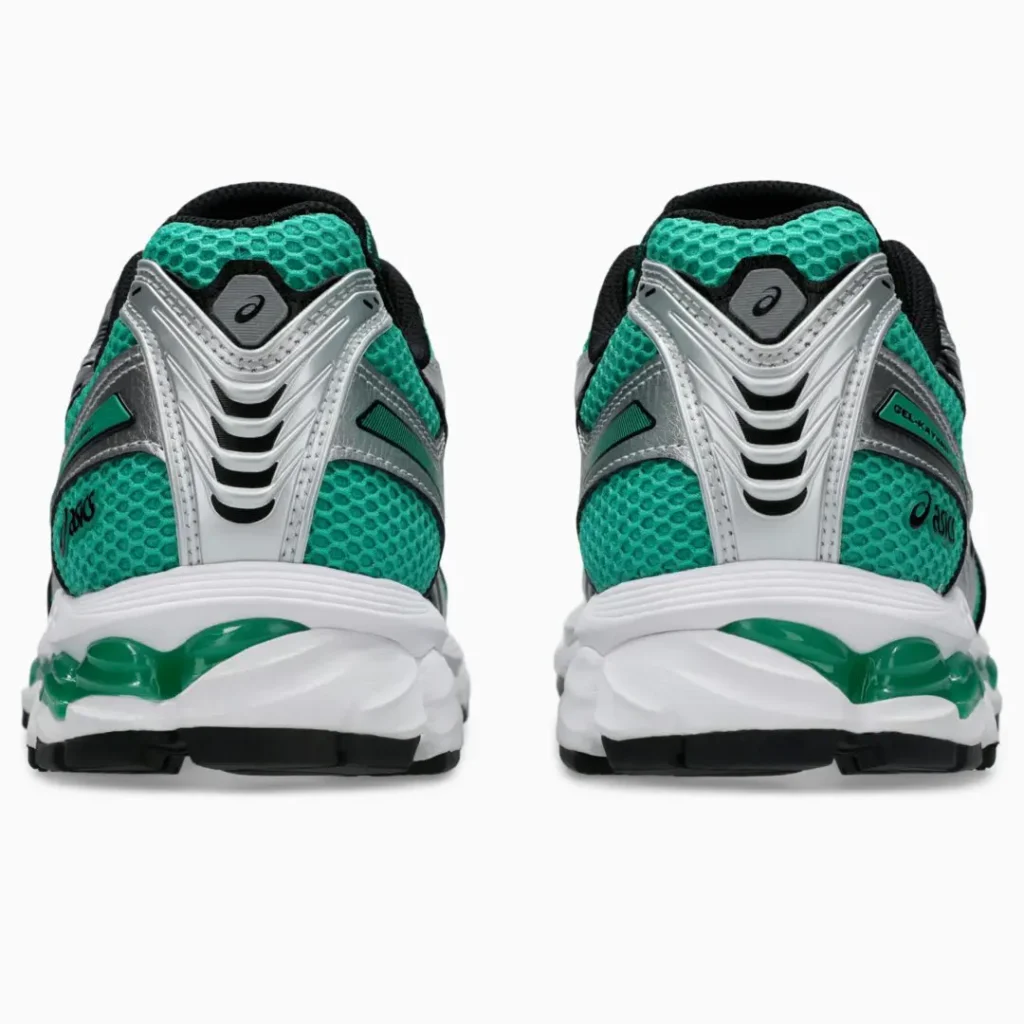 Rear heel view of the ASICS GEL-KAYANO 14 displaying sculpted metallic silver heel support, teal mesh collar panels, black ASICS logos, and green GEL cushion integrated into the white mid