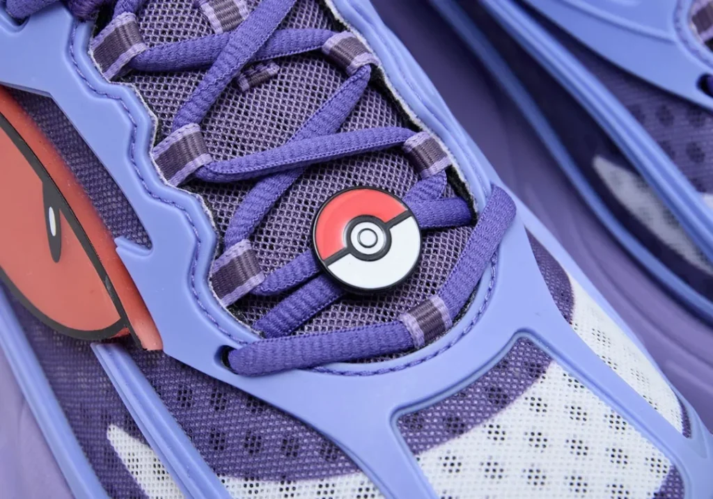 Close-up of the Gengar-inspired sneaker highlighting the purple mesh upper, Poké Ball lace jewel, and oversized eye graphic integrated into the side panel