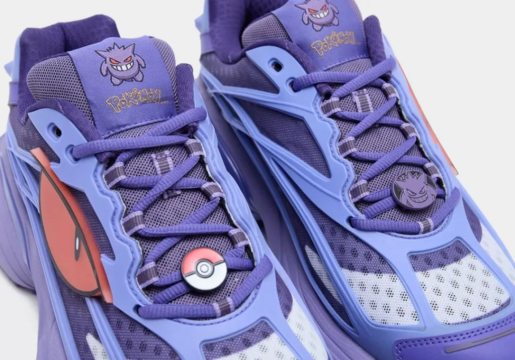 Close-up of the Gengar-inspired adidas running shoes highlighting purple mesh uppers, embroidered Gengar tongue logos, oversized eye graphic, Poké Ball and Gengar lace jewels, and layered TPU overlay