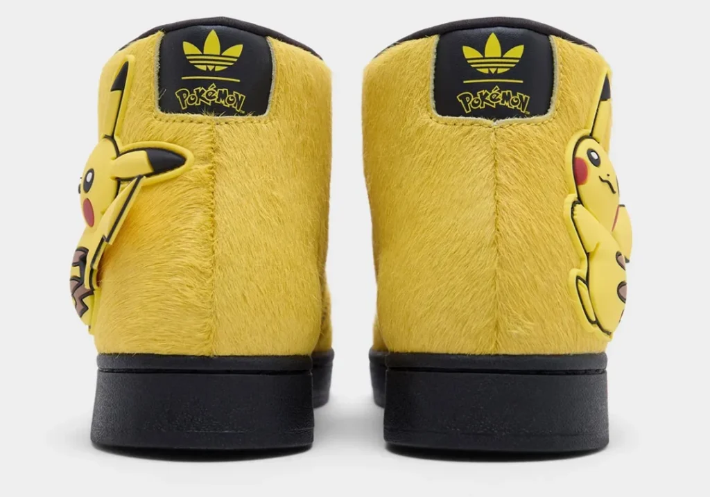 Rear view of the Pikachu-themed adidas Superstar Mid displaying Adidas Trefoil and Pokémon branding on the heel tabs with fuzzy yellow panel