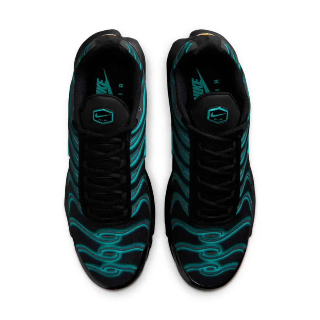 A bird's-eye view of the Nike Air Max Plus displays black laces, padded black tongues with teal Air branding, teal wave graphics across the toe boxes, and black sockliners printed with teal Nike Air logo