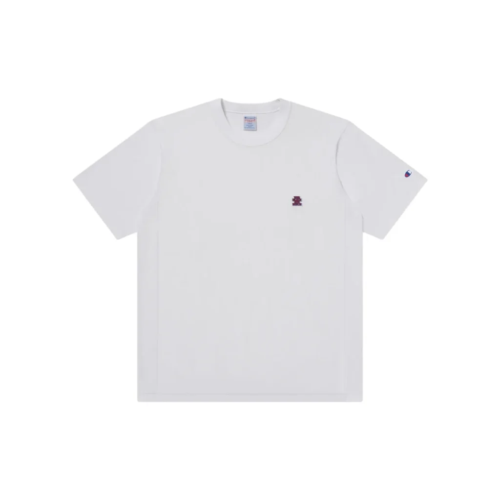 Front product image of the white Champion x The Black Eye Patch short sleeve Tee featuring a small embroidered chest logo and Champion sleeve embroidery on a plain white background