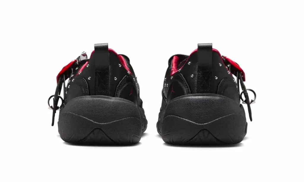 Rear view of the shoe pair displaying oversized sculpted heels, black pull tabs, metallic stud accents wrapping around the collars, and vibrant red interior pad