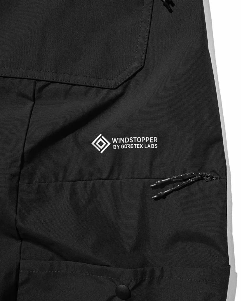 Black and khaki CLESSTE × +phenix utility half pants hanging side by side on a rack, showcasing oversized tailoring and technical outdoor construction