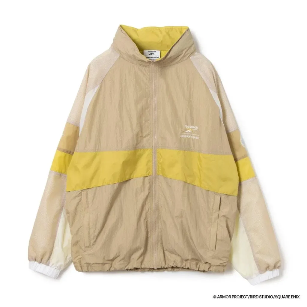 Front view of the beige and yellow Reebok × Dragon Quest hooded jacket featuring lightweight crinkled fabric, mesh sleeves, yellow stripe detailing, and embroidered collide brand