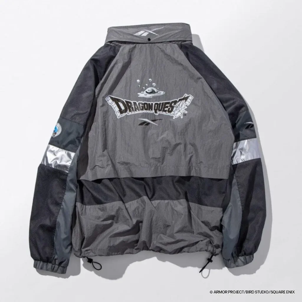 Rear view of the charcoal gray jacket with oversized Dragon Quest artwork featuring a metallic Slime graphic, reflective accents, and a relaxed technical sit