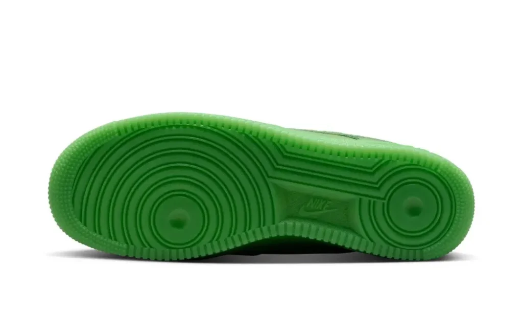 Bottom view of the bright green Nike Air Force 1 Low displaying the classic circular traction outsole pattern in matching green rubbe