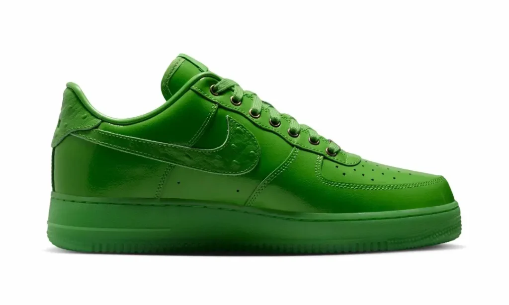 Medial side profile of the bright green Nike Air Force 1 Low highlighting smooth leather panels, tonal stitching, perforated toe box, and matching green outsole