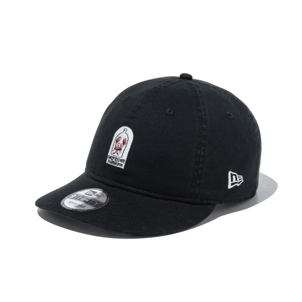 Black washed cotton curved brim cap featuring a bottle and crab patch on the front with white New Era logo on the side