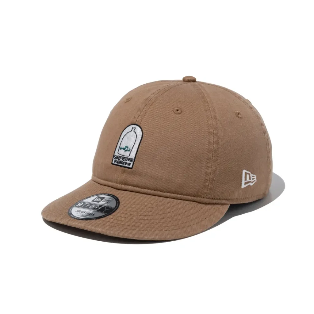Tan curved brim cap with a minimalist bottle and fish patch embroidered on the front and clean cotton construction
