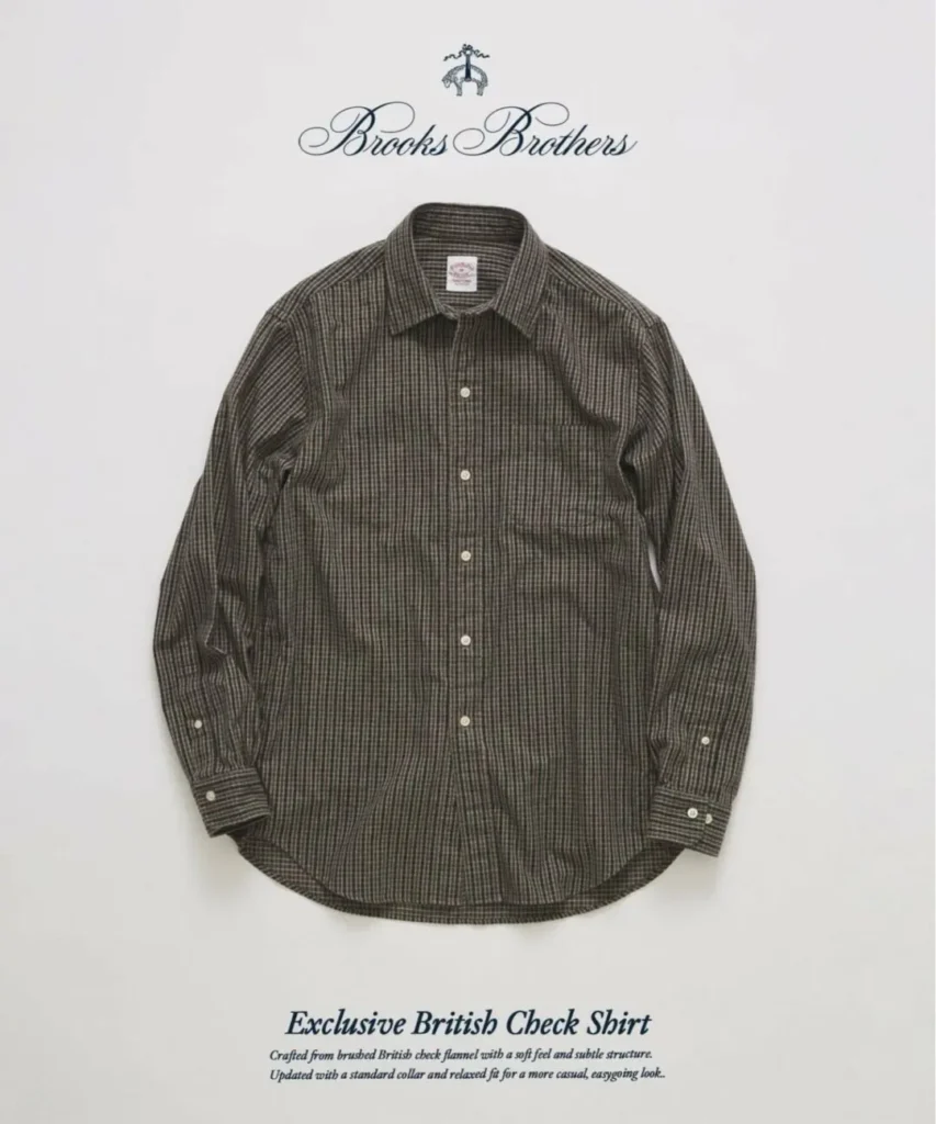 Front product view of a Brooks Brothers Exclusive British Check Shirt in an olive, brown, and black micro-check pattern. The relaxed-fit brushed flannel shirt includes a standard point collar, left chest pocket, white button closure, long sleeves with adjustable cuffs, and a gently curved hem on a neutral studio background