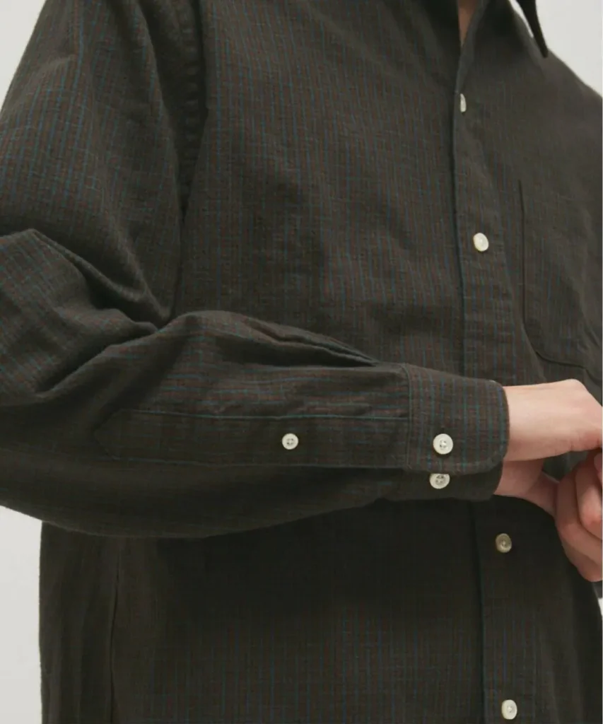 Detailed close-up of the charcoal Brooks Brothers British Check Shirt focusing on the sleeve, double-button adjustable cuff, chest pocket edge, and fine micro-check brushed flannel fabric with contrasting white button