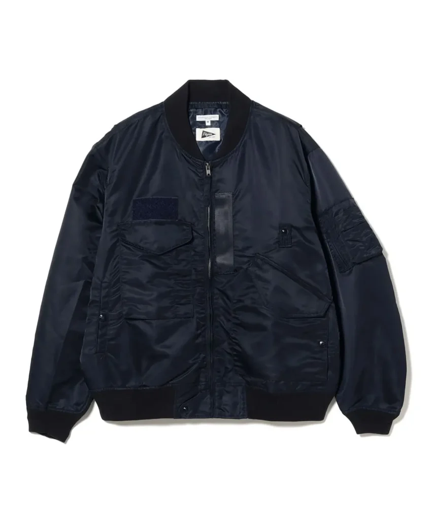 Navy nylon bomber jacket featuring a ribbed collar, zip-front closure, oversized cargo pockets, hook-and-loop chest panel, utility sleeve pocket, and ribbed cuffs and hem