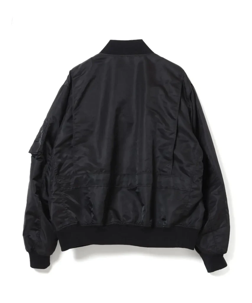 ear view of the black nylon bomber jacket with a clean minimalist back panel, ribbed collar, cuffs, and hem, highlighting its relaxed military-inspired sil