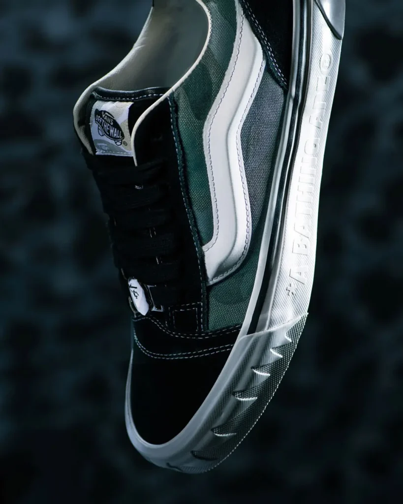 Side profile of the olive camouflage BAPE STA x Vans sneaker showcasing black suede overlays, oversized white star logo, Vans side stripe, metallic lace hardware, and embossed A BATHING APE text on the chunky serrated mid