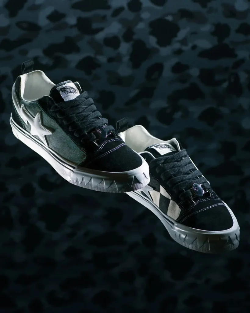 Pair of black and olive camouflage BAPE STA x Vans shoe suspended against a dark camouflage background, emphasizing the oversized white star logos, serrated midsoles, thick laces, and connective design detail