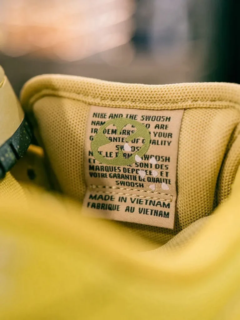 Interior size label of the Nike SB Dunk Low Pro showing production information and a green Swoosh logo printed on the woven tag