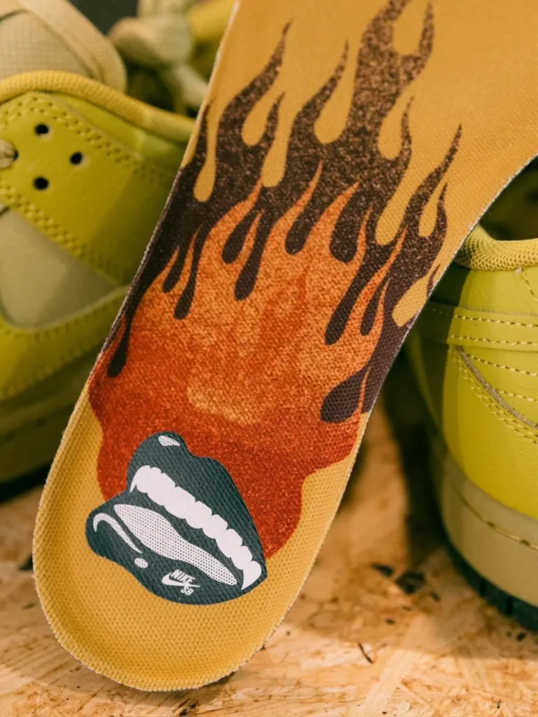 Close-up of the Nike SB Dunk Low Pro insole featuring a flame graphic above an open mouth illustration with Nike SB branding printed near the heel