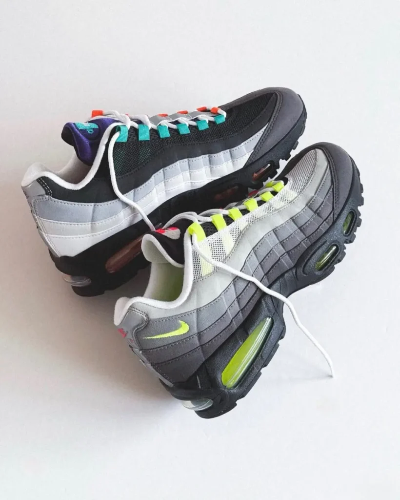 Pair of mismatched Nike Air Max 95 shoe arranged toe-to-toe, showcasing asymmetrical black and white uppers, tincture lace loops, and tinted Air unit