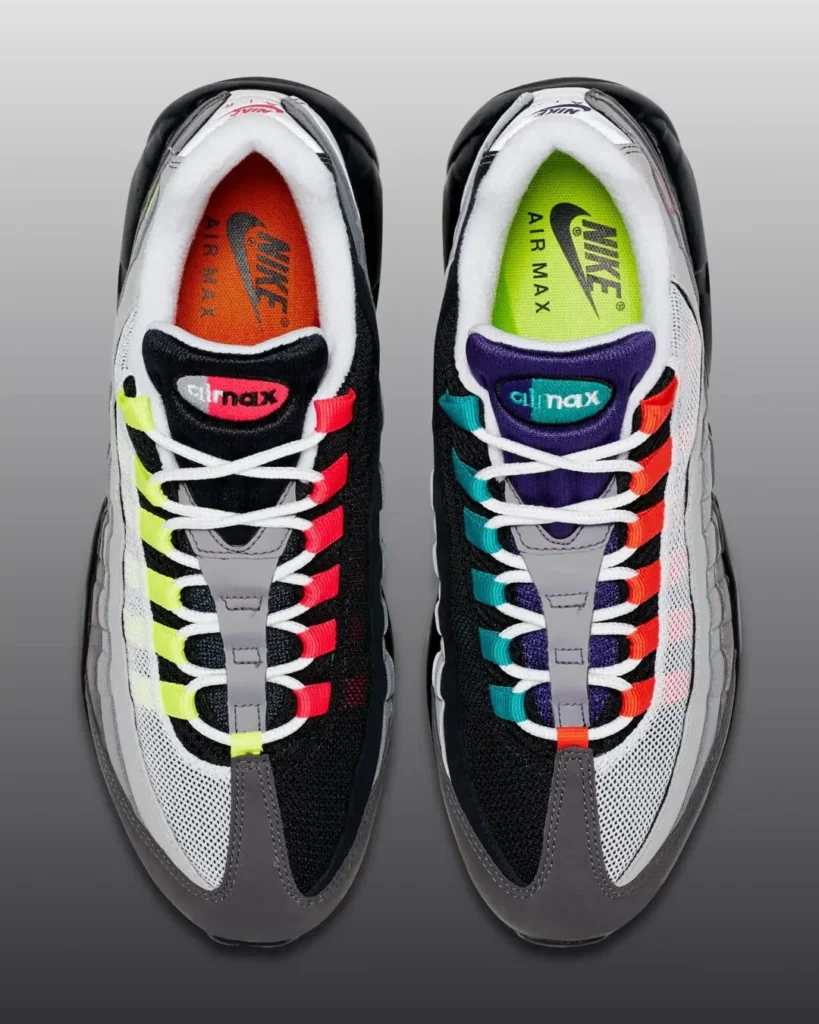 Top-down view of mismatched Nike Air Max 95 shoe featuring neon yellow, teal, orange, and pink lace loops, contrasting black and white mesh uppers, and vibrant mismatched insole