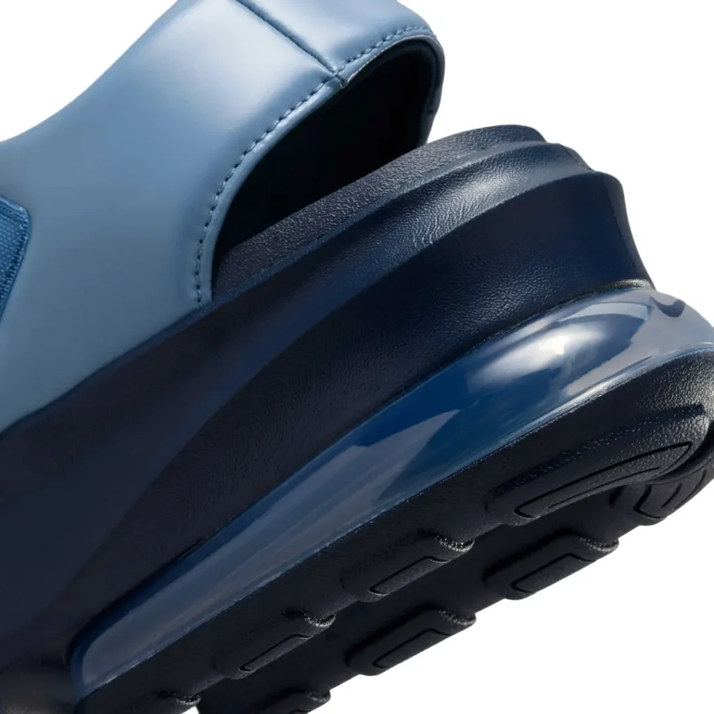 Macro close-up of the Nike Air Max platform sandal's heel. The image showcases the transparent blue-tinted Air Max unit integrated into the thick navy foam midsole, revealing the cushioning technology while highlighting the textured sidewall and durable rubber outsole beneath