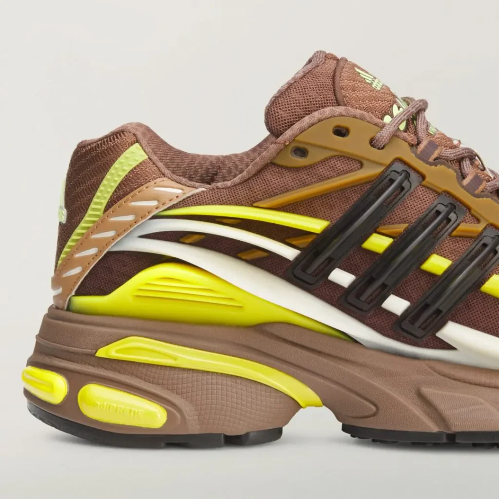 Close-up of the adidas x Ne.jelly Virginia shoe lateral heel featuring fluorescent yellow TPU accents, white wave-shaped overlays, textured brown midsole, and view cushion detail