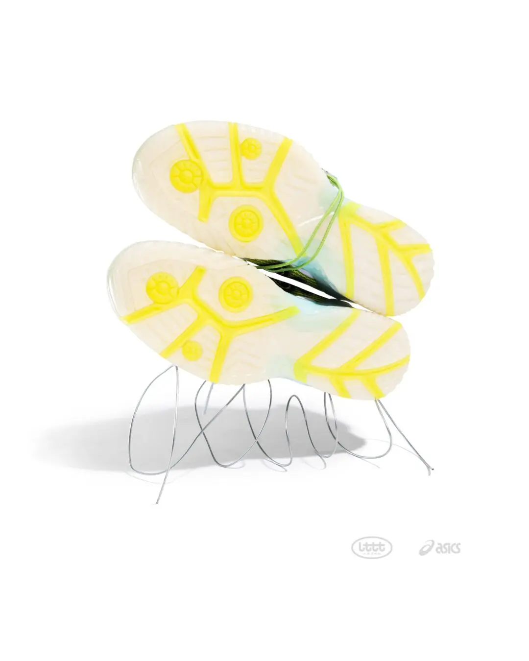 Translucent yellow outsole of the lime green ASICS x Lttt table tennis shoe displayed upside down on a sculptural wire stand, highlighting the bright traction pattern and semi-transparent rubber construction against a clean white background.