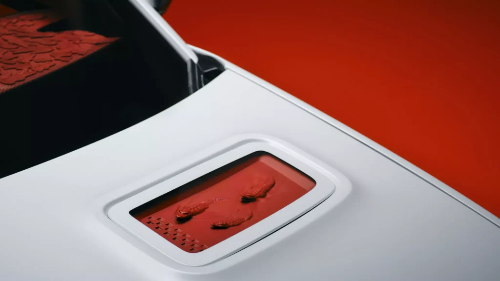 Close-up of the Alpine A290 Rallye hood featuring a recessed red panel with three sculpted crocodile emblems, highlighting the collaboration's signature design detail