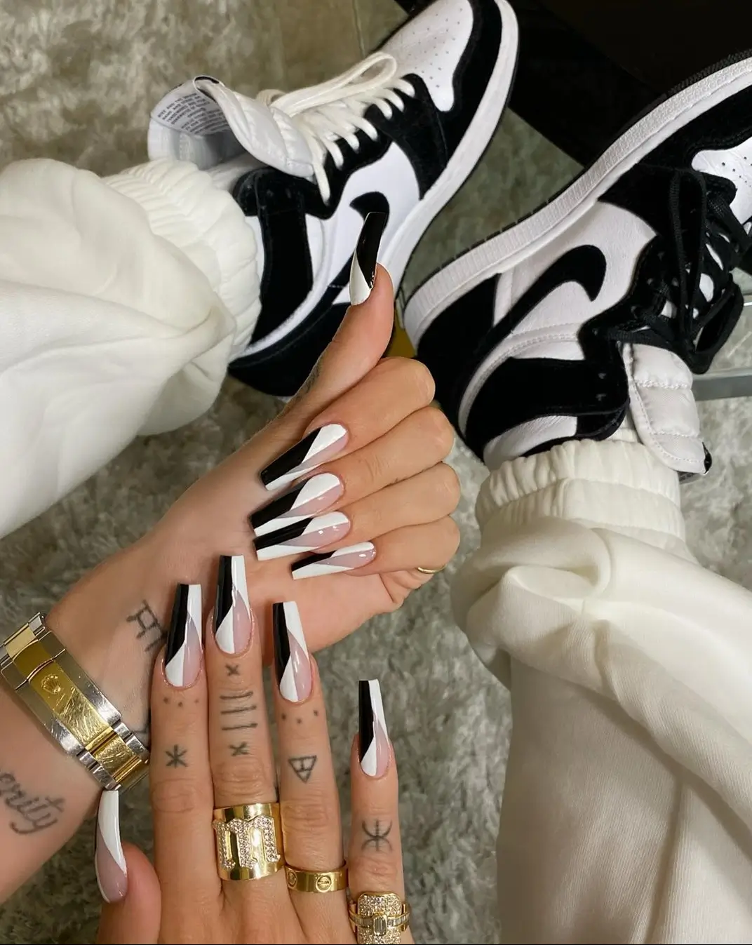 Pair of Air Jordan 1 High sneakers in glossy varsity red and white patent leather, featuring metallic Wings logos, exposed foam tongues, white laces, and custom nail-inspired detailing.