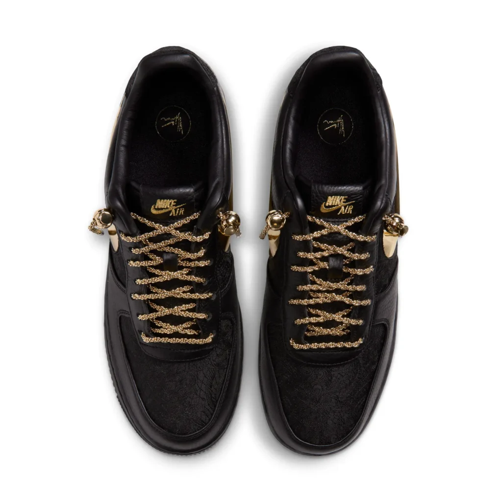 Top-down view of the Nike Air Force 1 by Yoon featuring a black premium leather upper, metallic gold chain laces, reflective gold Swooshes, and embroidered gold Nike Air brand