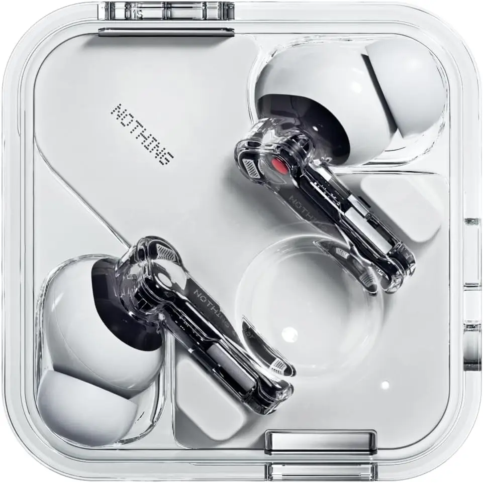 Close-up of the white Nothing Ear (3a) wireless earbuds inside their transparent square charging case. The earbuds feature translucent stems with visible internal components, black acoustic housings, and the signature red accent on the right earbud, highlighting Nothing's industrial design language.