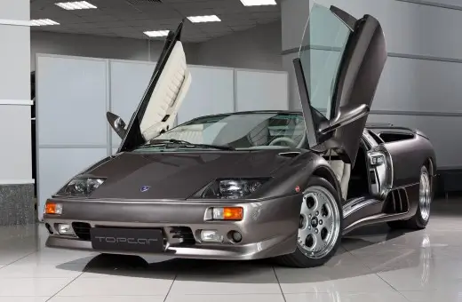 Original Lamborghini Diablo scissor doors raised, showing the cream leather interior and factory bodywork of the donor platform