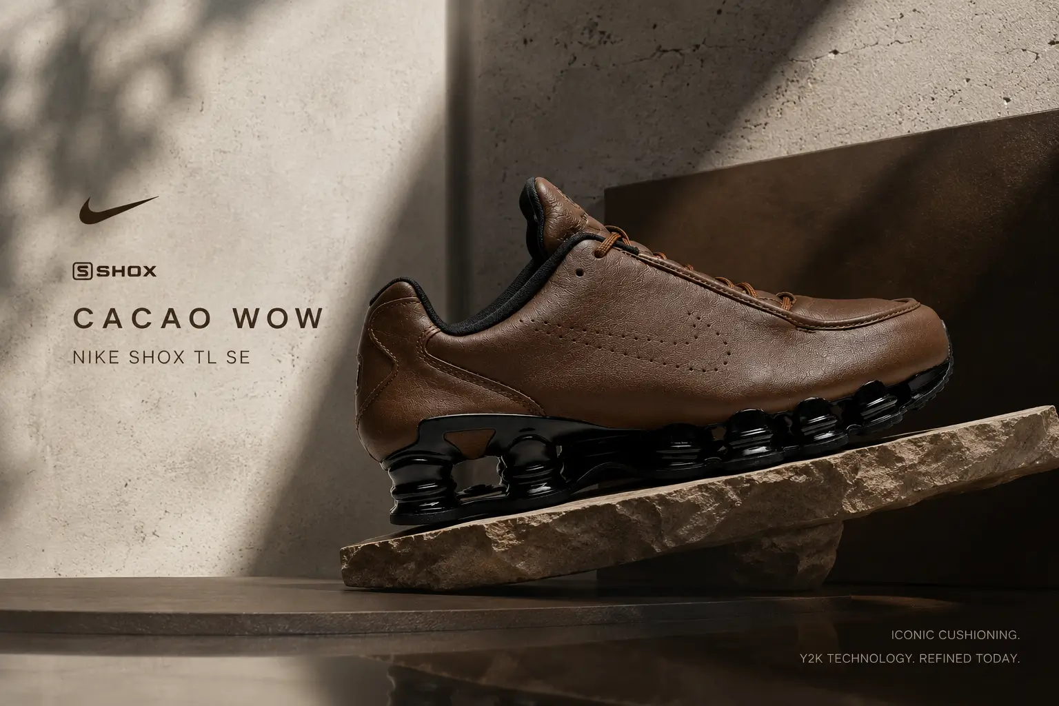 Nike Shox TL SE 'Cacao Wow' in profile, featuring a premium Cacao Wow leather upper with a perforated Swoosh, black collar lining, and glossy full-length Shox cushioning columns. Displayed atop a textured stone pedestal under warm natural light, the campaign image emphasizes the silhouette's refined leather construction and signature mechanical sole.
