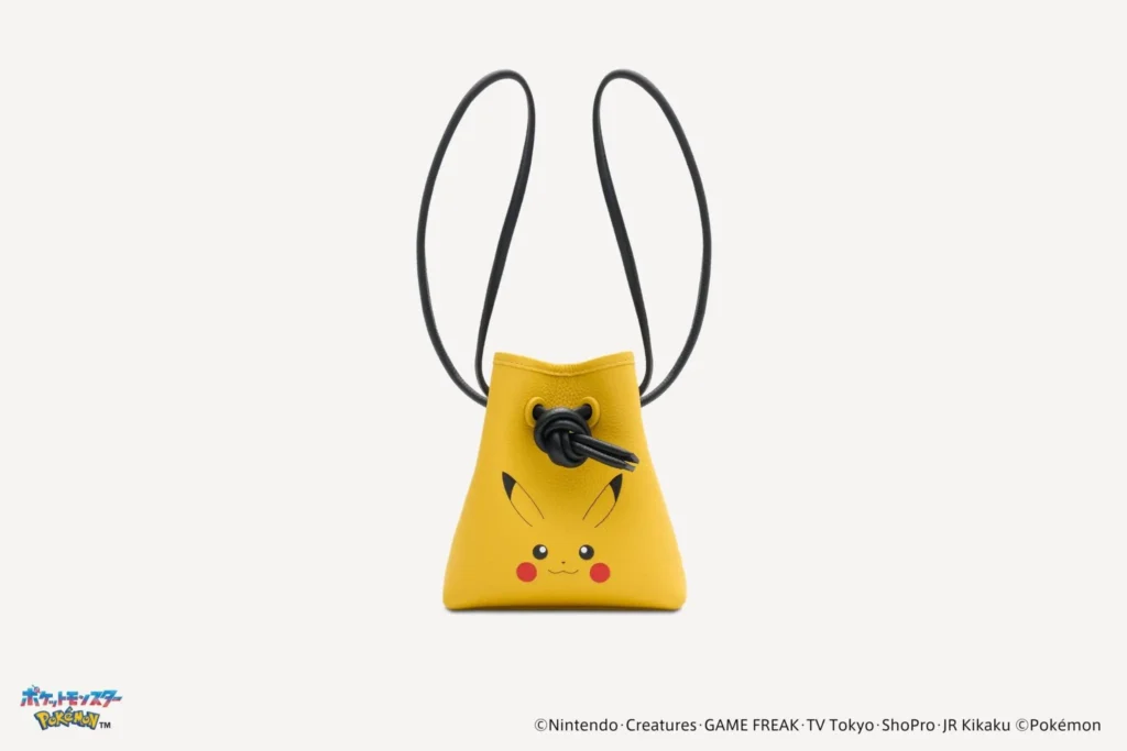 Small yellow leather drawstring bucket bag featuring Pikachu's face with black cord closure and shoulder strap, photographed against a white background