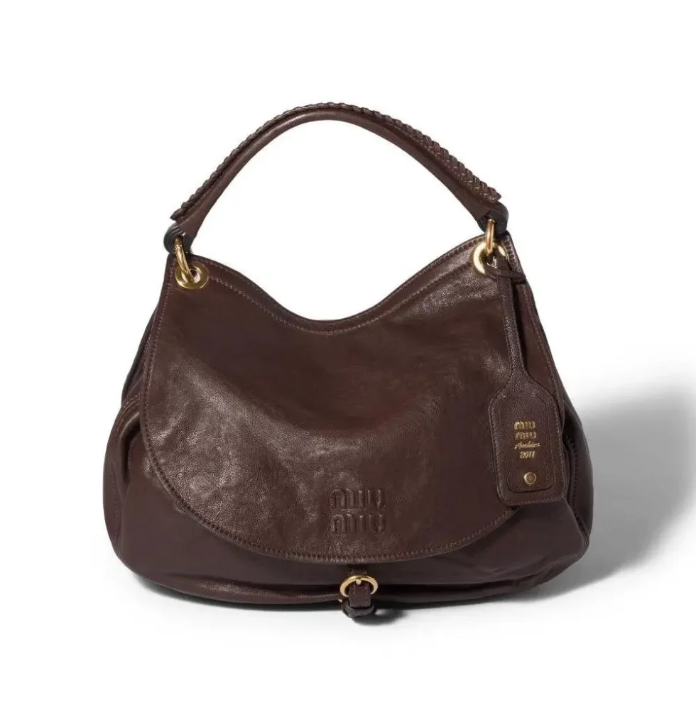 Dark brown Miu Miu leather shoulder bag with a soft flap design, braided handle, gold hardware, and an embossed logo