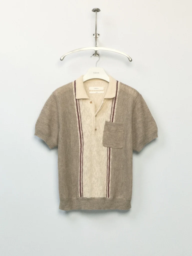 Short-sleeve knit polo in beige and cream with vertical striped detailing, ribbed texture, and a patch chest pocket on a hanger