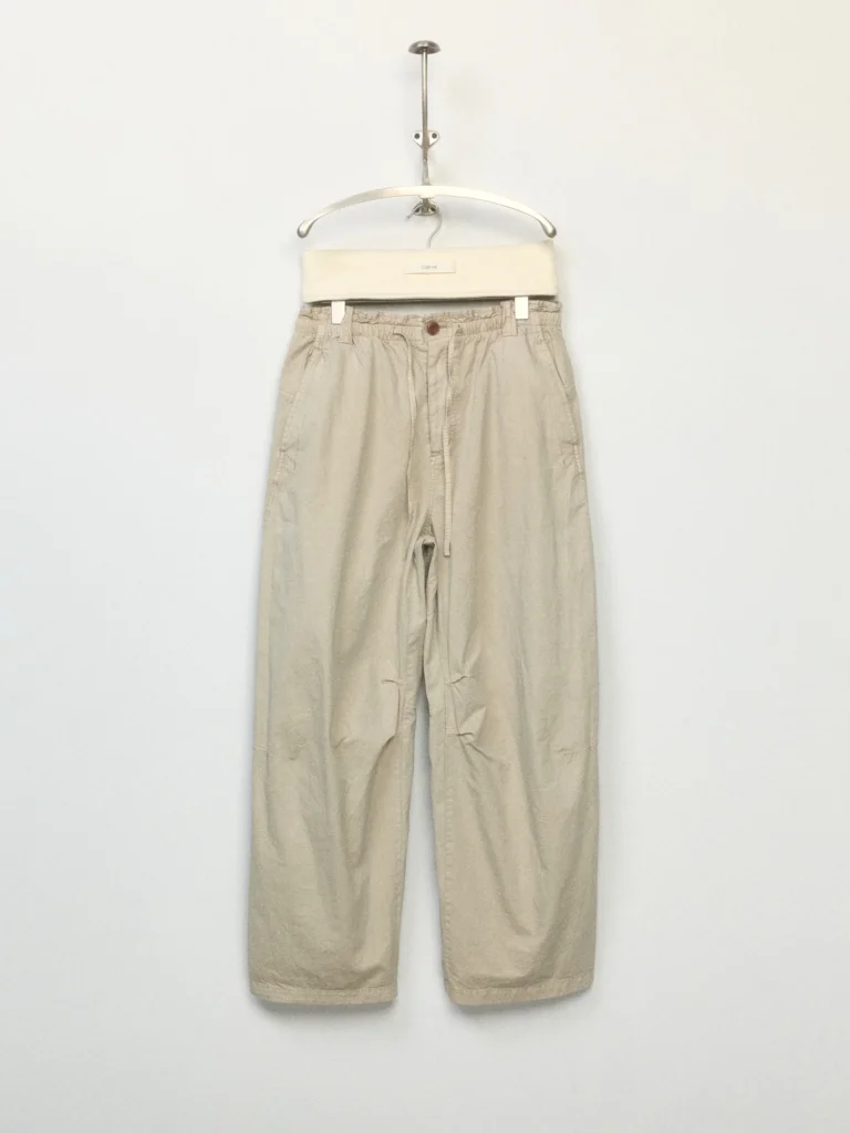 Relaxed-fit cream drawstring trousers with an elastic waistband, cropped wide-leg silhouette, and lightweight textured fabric