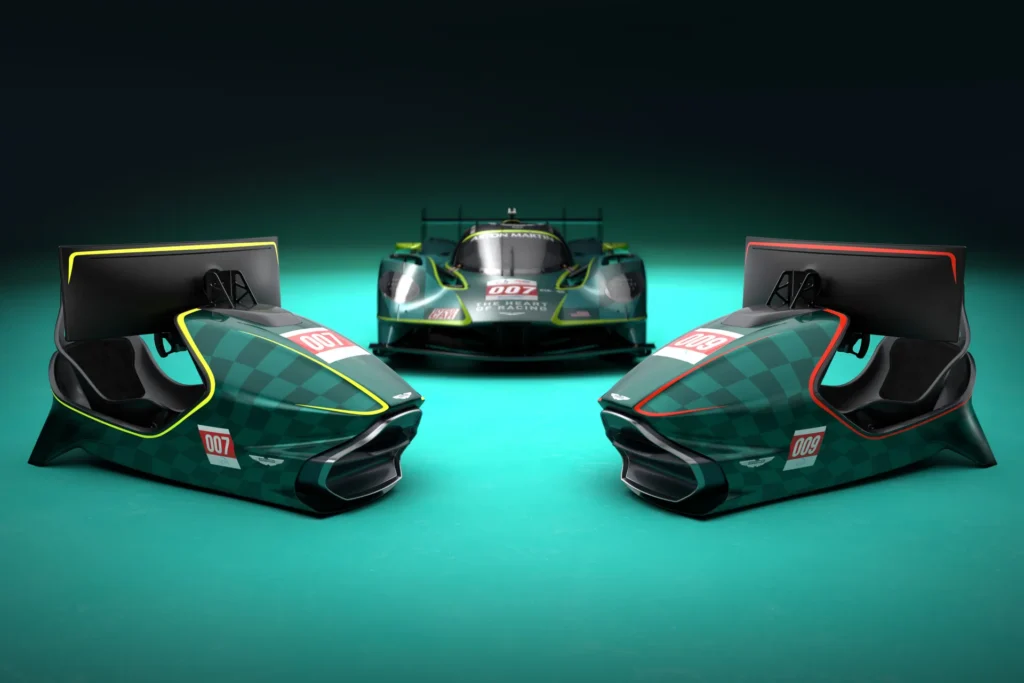 Pair of Aston Martin-inspired racing simulator cockpits positioned in front of an Aston Martin race car, showcasing matching British racing green styling, curved displays, racing seats, and premium motorsport-inspired design