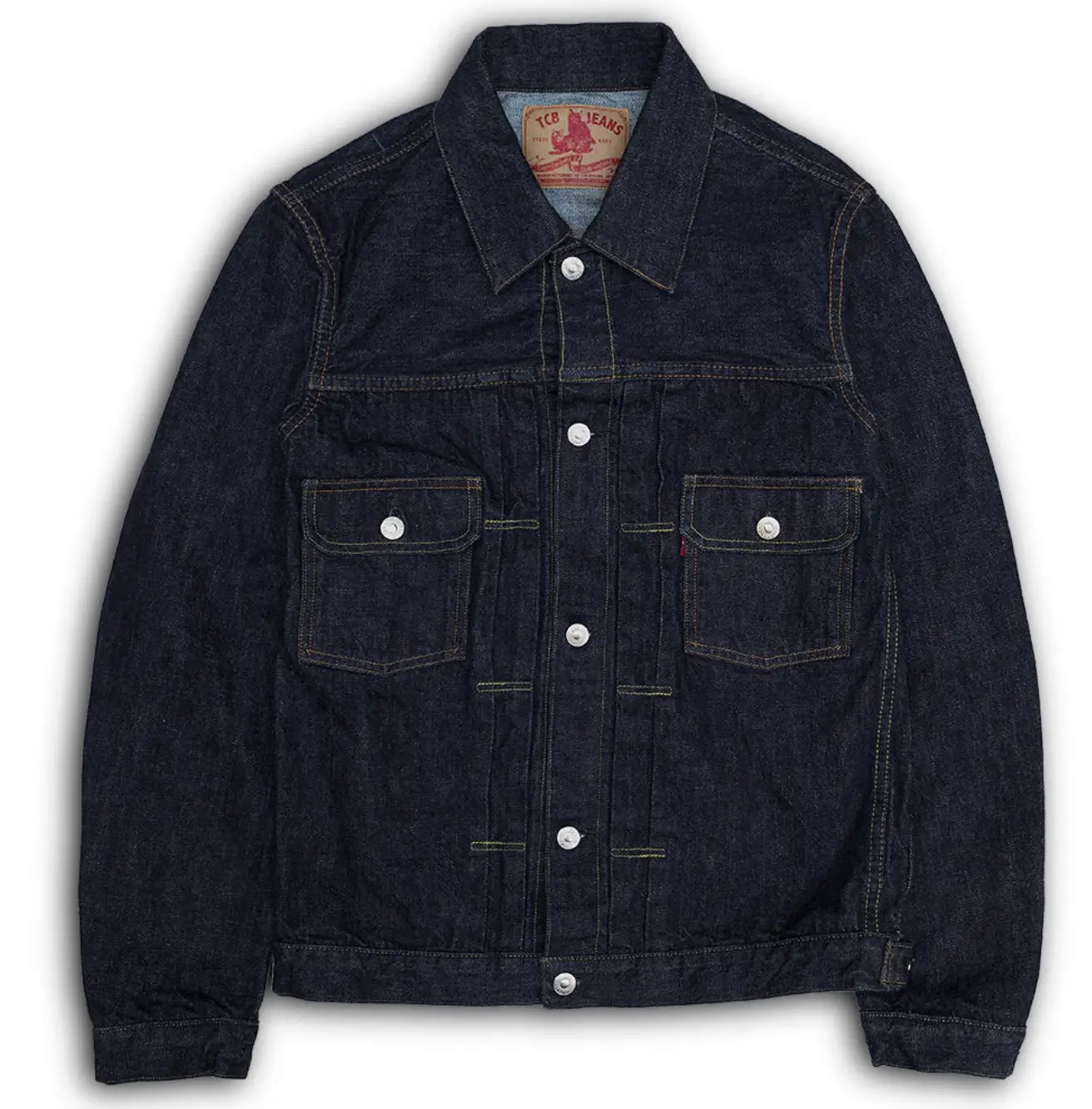 Dark indigo TCB Jeans selvedge denim jacket shown flat against a white background, featuring a pointed collar, silver metal buttons, contrast stitching, two button-flap chest pockets, and adjustable waist tabs.