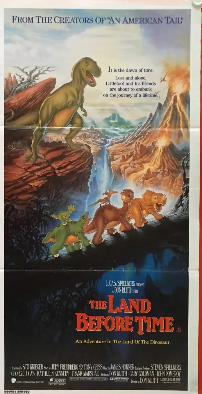 Original theatrical poster for The Land Before Time (1988) featuring Littlefoot and his dinosaur companions crossing a rocky prehistoric landscape beneath erupting volcanoes, while the towering Tyrannosaurus Shar looms above. The artwork includes the classic film title and credits for the Don Bluth-directed animated adventure produced by Steven Spielberg and George Lucas.