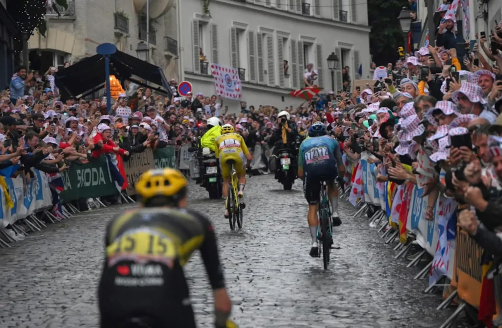 Cyclists race through rain-soaked Paris streets during the Tour de France finale as the yellow jersey leads through roaring crowds lining the cobblestone course