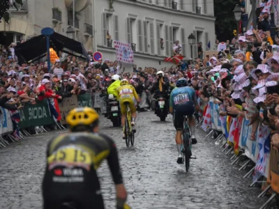 Cyclists race through rain-soaked Paris streets during the Tour de France finale as the yellow jersey leads through roaring crowds lining the cobblestone course