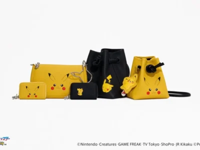 Group shot of Pokémon leather accessories including Pikachu wallets, a yellow shoulder bag, black and yellow drawstring bucket bags, a Pikachu luggage tag, and a silver Pikachu head key ring displayed together on a white background