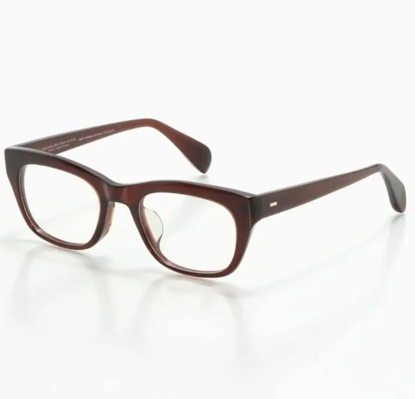 Dark brown acetate eyeglasses shown at an angle against a white background, featuring a squared cat-eye frame shape, glossy finish, and a small gold-tone logo detail on the temple.