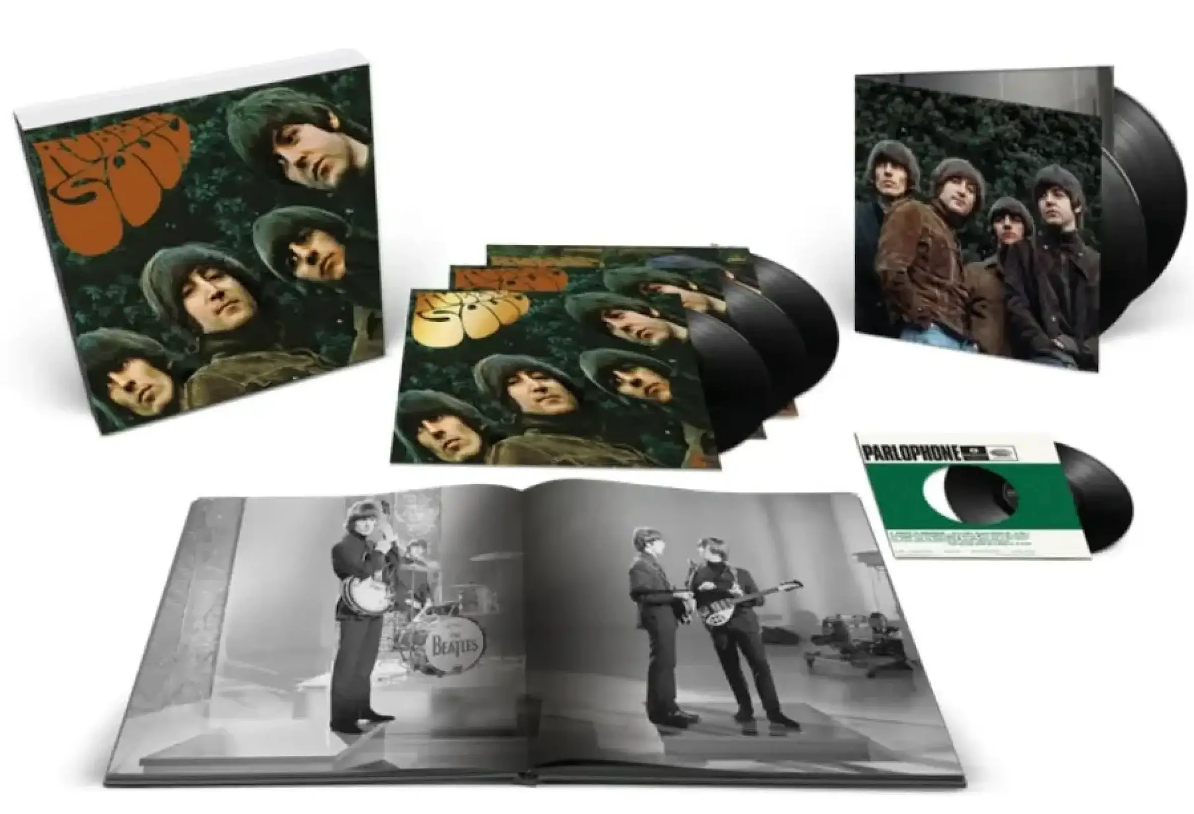 The Beatles' Super Deluxe vinyl edition displayed with multiple LPs, album sleeves, a hardcover photo book, a 7-inch single, and gatefold packaging featuring the iconic 'Rubber Soul' artwork and archival band photography.